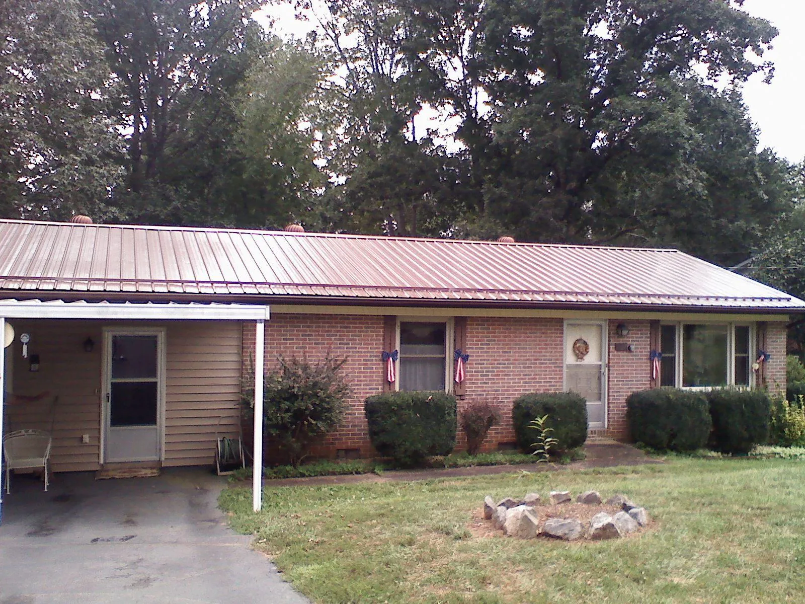 Bronze metal roof and carport on a brick ranch home — Roof Repair work by our crew in Delaware
